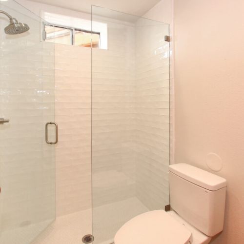 Bright white shower and lavoratory ensuite for Guest House ensuite bathroom.